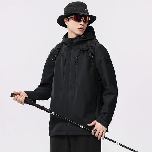 Man wearing a black windproof and waterproof outdoor jacket with a hood, sports sunglasses, and a bucket hat, holding a trekking pole. - Image 6