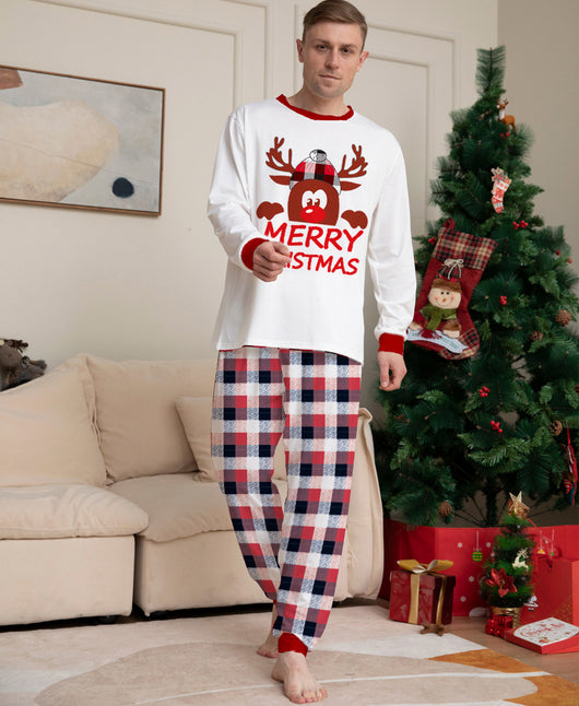 Young girl in a white long-sleeve Christmas pajama top with a reindeer graphic and red plaid pajama pants. - Image 2