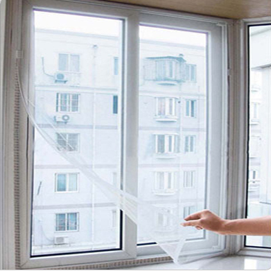White mosquito screen applied to a window, with a hand gently pulling a corner to show its fine mesh texture. - Image 5