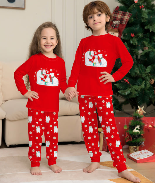 Family of four wearing matching red Christmas pajamas with polar bear and snowflake print, standing by a Christmas tree. - Image 12
