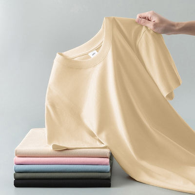 Light gray short-sleeve t-shirt with a round neck, held up to show its smooth fabric. A stack of folded t-shirts in various colors is visible in the background. - Image 11