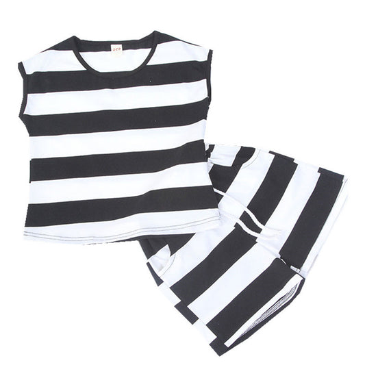 Mother and daughter in matching black and white striped short-sleeved tops and shorts, standing outdoors.