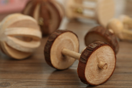 Set of natural wooden hamster toys including dumbbell shapes, a spherical bell toy, and two cylindrical bell toys, with a hamster. - Image 6