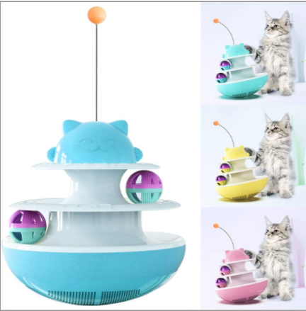 A playful kitten stands on its hind legs, batting at a dangling toy attached to a green and white multi-level cat track toy with rolling balls. - Image 2