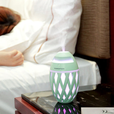Light green football-shaped humidifier with a decorative lattice pattern and a power button on top. - Image 2