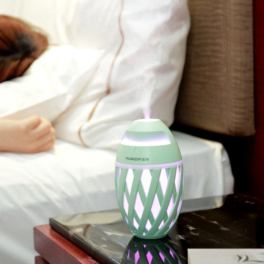 Light green football-shaped humidifier with a decorative lattice pattern and a power button on top. - Image 2