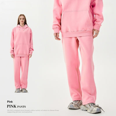 Young woman wearing a pink fleece-lined hoodie and matching sweatpants tracksuit set with a drawstring hood and kangaroo pocket. - Image 4