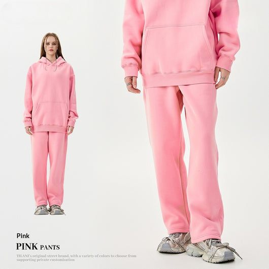 Young woman wearing a pink fleece-lined hoodie and matching sweatpants tracksuit set with a drawstring hood and kangaroo pocket. - Image 4