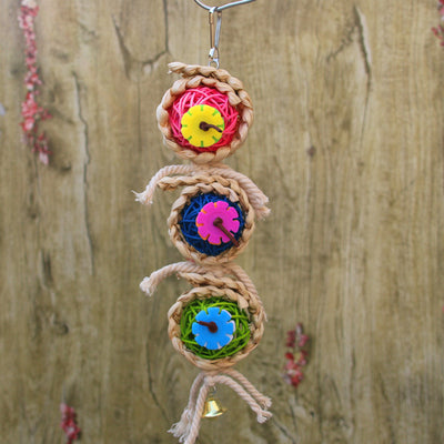 Colorful bird toy with three woven vine balls, internal pink, blue, and green string, felt flowers, and a bell. - Image 2