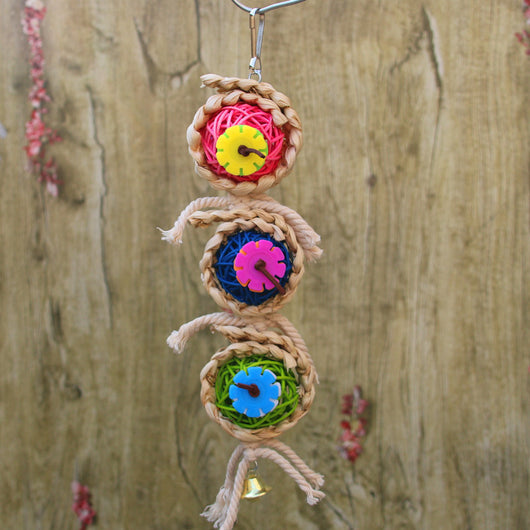 Colorful bird toy with three woven vine balls, internal pink, blue, and green string, felt flowers, and a bell. - Image 2