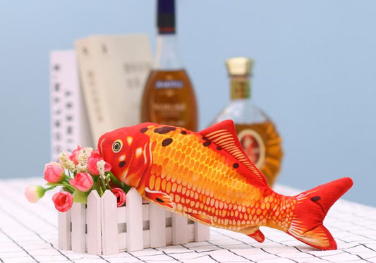 Realistic plush fish cat toy with yellow and brown scales, black fins, and a white USB charging cable.