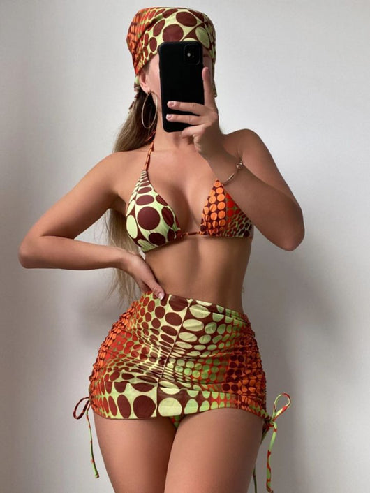 Women's printed split bikini swimsuit set with halter top, high-cut bottom, sarong skirt, and headscarf in green, brown, and orange optical dot pattern. - Image 3