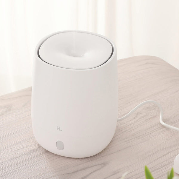 White mini aromatherapy machine with a minimalist design, featuring a top mist outlet and a single control button.