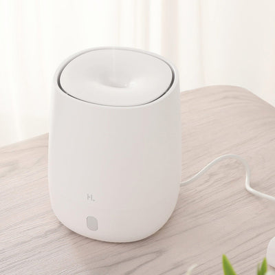 White mini aromatherapy machine with a minimalist design, featuring a top mist outlet and a single control button.