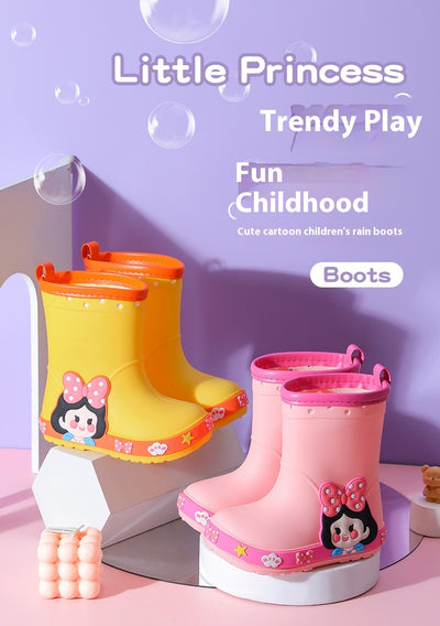 Bright yellow children's rain boots with a green cartoon dinosaur design and orange trim, held by hands. - Image 23