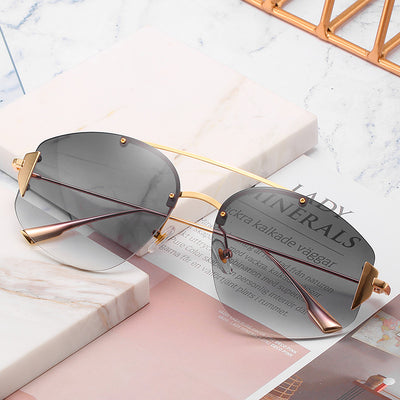 Women's fashion rimless sunglasses with blue to yellow gradient lenses and a gold-colored metal frame. - Image 2