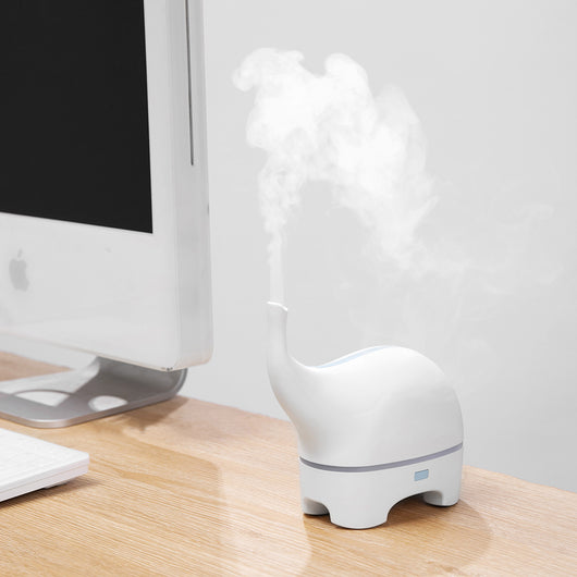 Pink elephant-shaped ultrasonic aromatherapy machine with a subtle light band and trunk-like mist outlet.