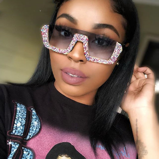 Black square sunglasses with a wavy top frame embellished with brown and clear rhinestones and gradient smoke lenses.