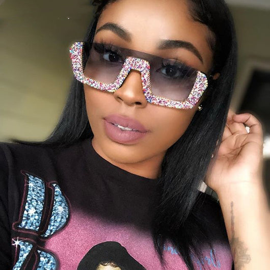 Black square sunglasses with a wavy top frame embellished with brown and clear rhinestones and gradient smoke lenses.