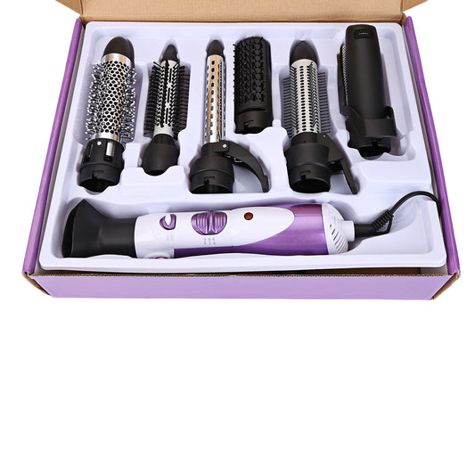 Seven-in-one hair dryer set with white and purple main unit and multiple black styling attachments in an open box.