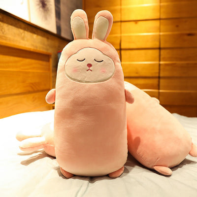 Pink rabbit plush doll with closed eyes, soft and elongated, standing on a bed. - Image 6