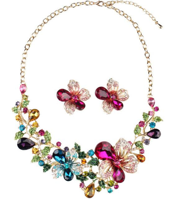 Gold-tone statement necklace and matching stud earrings with multi-colored crystal floral design.