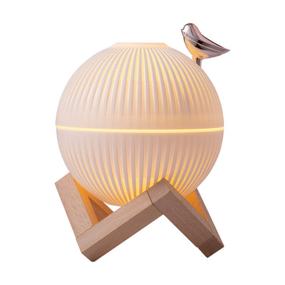 White spherical humidifier with ribbed texture, warm glow, metallic bird accent, and light brown wooden stand. - Image 7