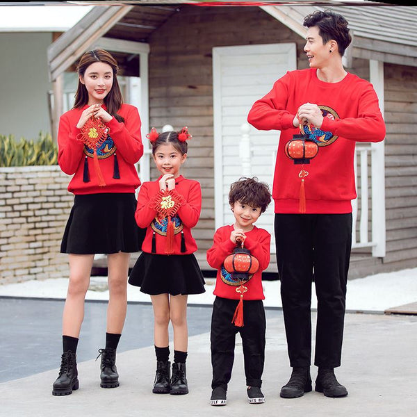 Family of four in matching red long-sleeve tops with a rabbit graphic, celebrating the Year of the Rabbit.