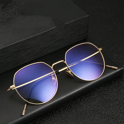 Silver metal anti-blue light glasses with rounded hexagonal clear lenses and black temple tips on a white background.