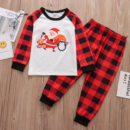 Christmas pajama set with a white long-sleeve top featuring Santa, reindeer, and penguin, and red and black plaid pants. - Image 2