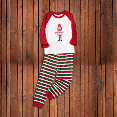 Matching family Christmas pajamas with white raglan tops, red sleeves, and a nutcracker graphic, paired with red, green, and white striped pants. Includes adult - Image 15