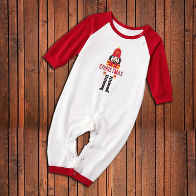 Matching family Christmas pajamas with white raglan tops, red sleeves, and a nutcracker graphic, paired with red, green, and white striped pants. Includes adult - Image 19