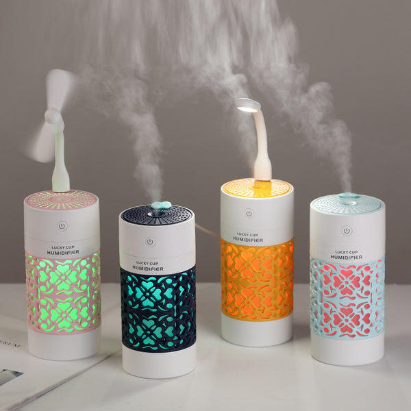 Light blue and white Lucky Cup humidifier with a decorative heart and floral cutout pattern. Features a power button.