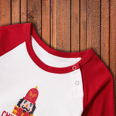 Matching family Christmas pajamas with white raglan tops, red sleeves, and a nutcracker graphic, paired with red, green, and white striped pants. Includes adult - Image 13