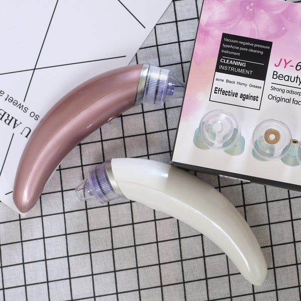 Rose gold and white electric blackhead suction instruments with clear heads, displayed next to their product box.