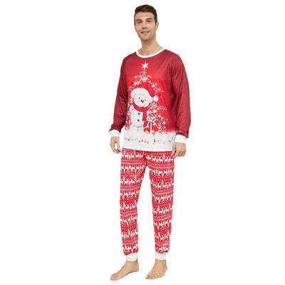 Family of four wearing matching red Christmas pajamas with snowman tops and reindeer fair isle pants, sitting by a Christmas tree. - Image 2
