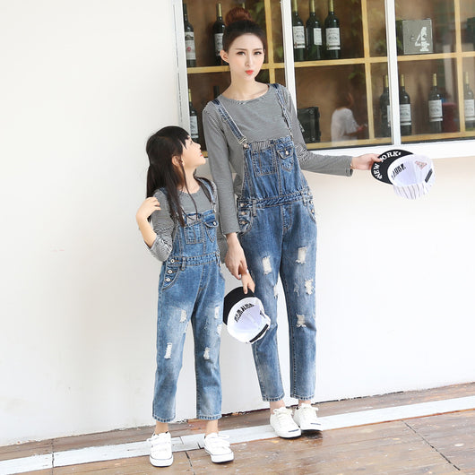 Mother and daughter wearing matching distressed denim overalls over black and white striped long-sleeve shirts. - Image 5