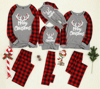 Family Christmas pajama set with grey long-sleeve tops featuring "Merry Christmas" and reindeer antlers, paired with red and black buffalo plaid pants.