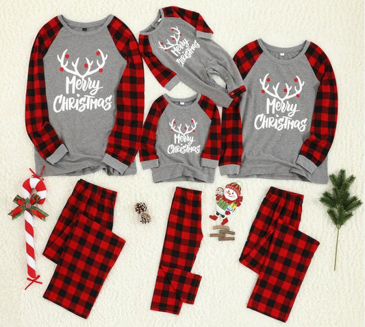 Family Christmas pajama set with grey long-sleeve tops featuring "Merry Christmas" and reindeer antlers, paired with red and black buffalo plaid pants.