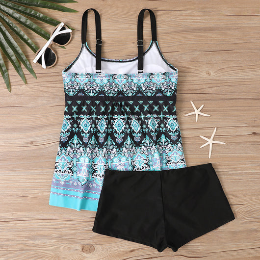 Woman in a black and white abstract print tankini top with black swim shorts on a sunny beach. - Image 22