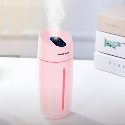 White desktop humidifier with blue LED light strip and control buttons, emitting mist on a wooden surface. - Image 9