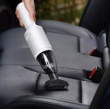 Dark gray cylindrical handheld vacuum cleaner in a car's cup holder, ready for quick interior cleaning. - Image 14