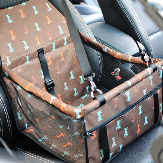 Light grey pet car booster seat with black mesh sides and adjustable straps, installed on a black and red car seat. - Image 11