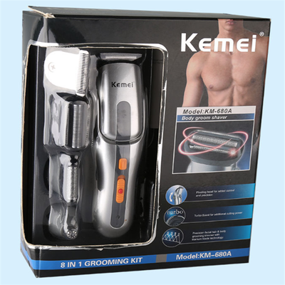 Kemei multi-function hair clipper set with silver and black body, orange buttons, and multiple interchangeable heads on a black charging base. - Image 6