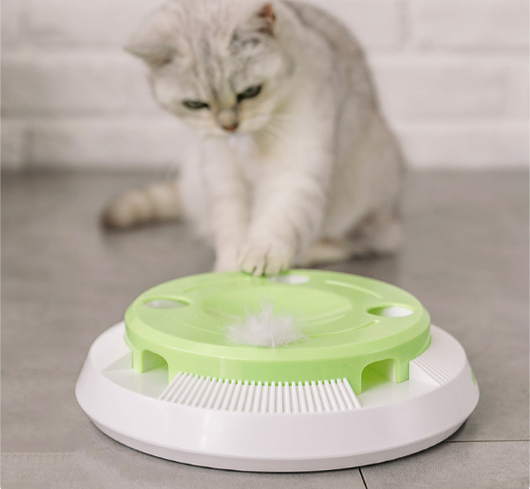 Round electric cat toy with a white base and a lime green top, featuring a rotating white feather.