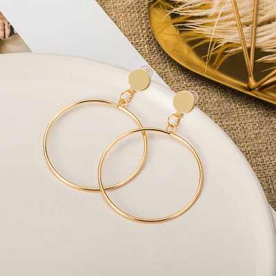 Pair of silver geometric round hoop earrings with a small circular stud and thin, large hoops. - Image 7