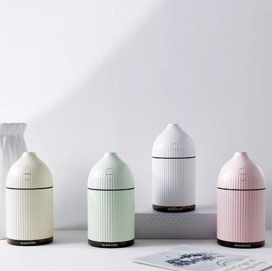 Pink ribbed aromatherapy diffuser and ultrasonic humidifier with a transparent brown base and control buttons.