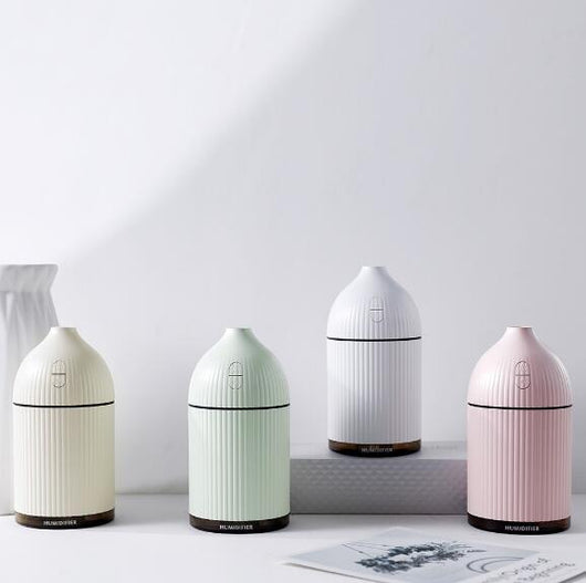 Pink ribbed aromatherapy diffuser and ultrasonic humidifier with a transparent brown base and control buttons.