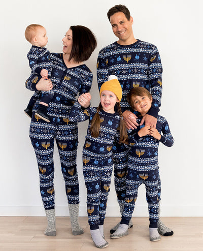 Family of five wearing matching navy blue Hanukkah pajamas with gold menorahs, blue dreidels, and white snowflakes. - Image 11