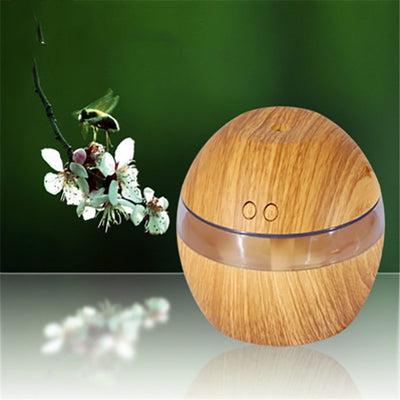 Spherical wood grain humidifier with a clear band, emitting mist, against a dark background with lotus flowers. - Image 4